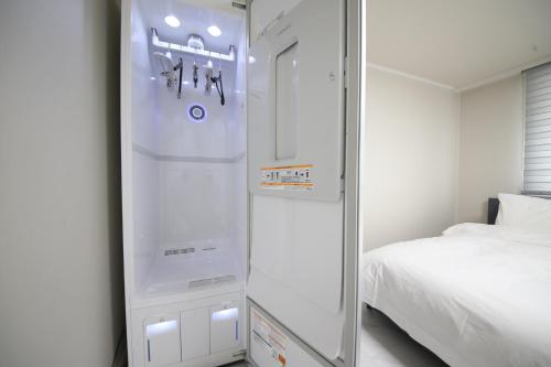 釜山HOTEL LENITH Seomyeon的旁边床的冰箱