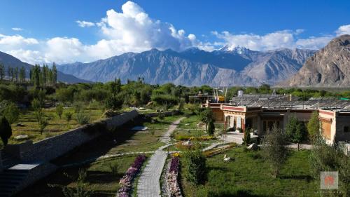 努布拉Lchang Nang Retreat-THE HOUSE OF TREES的享有村庄的空中景色,以群山为背景