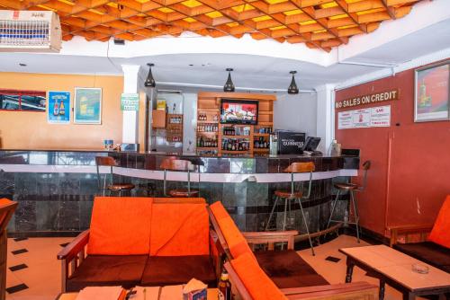 内罗毕Jupiter Guest Resort - Langata的餐厅里的酒吧,带橙色椅子