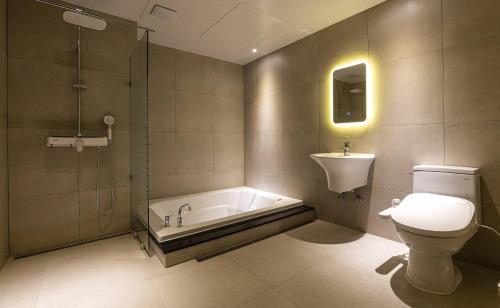 首尔Doksan 3S Hotel的带浴缸、卫生间和盥洗盆的浴室