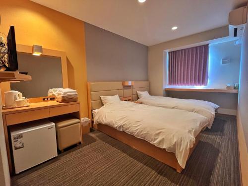贝冢市关西海滨酒店的配有一张床、一张书桌和一扇窗户的酒店客房