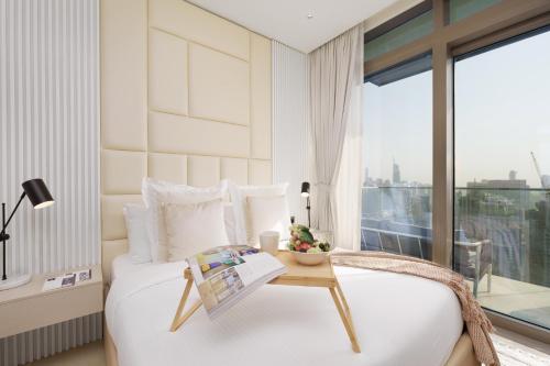 迪拜Maison Privee - Modern Luxury Apt with Spectacular Dubai Marina Vws的一间卧室配有一张带桌子和窗户的床