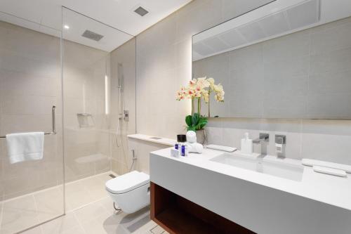 迪拜Maison Privee - Modern Luxury Apt with Spectacular Dubai Marina Vws的一间带水槽、卫生间和镜子的浴室