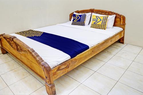GresikOYO 93108 Homestay H Syarif Syariah – RA Kartini的一张带枕头的木床