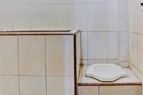 GresikOYO 93108 Homestay H Syarif Syariah – RA Kartini的浴室的架子上坐着白色的马桶
