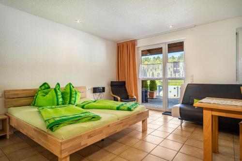 德根豪塞尔塔尔布赫曼度假公寓的一间卧室配有一张带绿色枕头的床