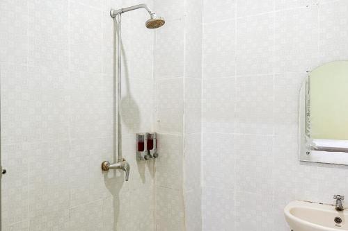 Global Inn Syariah Mitra RedDoorz near Juanda T1 Airport的浴室里设有玻璃门淋浴