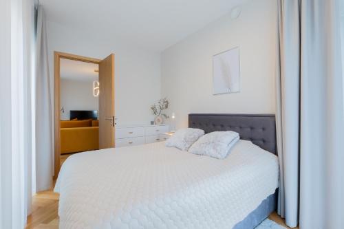 派尔努Cozy Stay Apartment的卧室配有白色的床和2个枕头