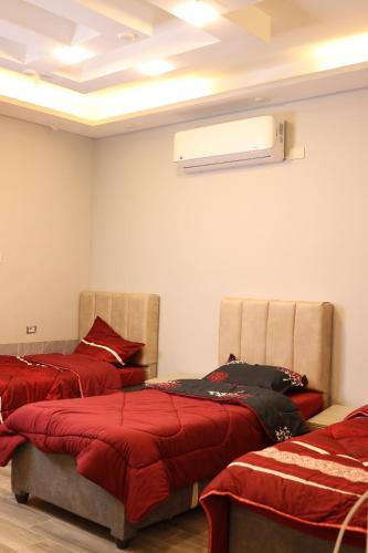 索瓦马شاليه ڤيو VIEW Chalet的客房设有两张带红色床单的床和天花板