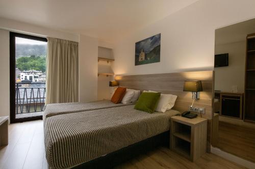 马萨纳Hotel Del Pui的酒店客房设有床和窗户。