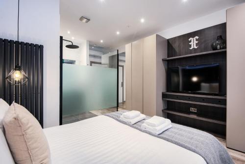 伦敦Circlelet Luxury Private Suite 3的一间卧室配有一张床和一台平面电视