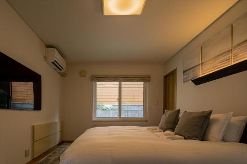 富良野Casi 15的卧室配有一张大白色床和窗户