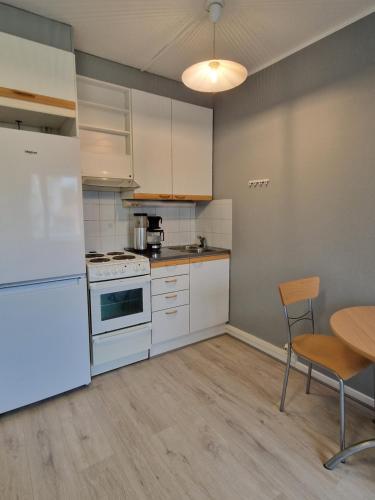 JokioinenHumppilantie的厨房配有白色家电和桌椅
