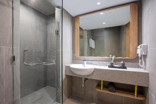 班贾尔马辛Harper Banjarmasin的一间带水槽、镜子和淋浴的浴室