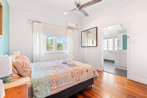 UranganPrivate Resort-style Queenslander at Hervey Bay的一间卧室配有一张床和吊扇