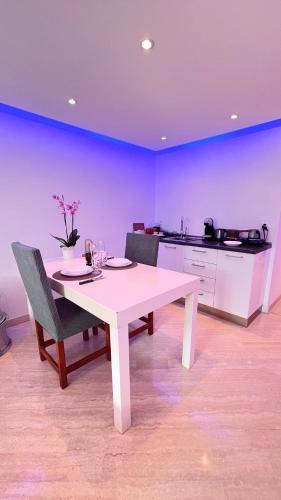 莫尔科泰CUORE OPENSPACE的一张带两把椅子的白色桌子和一间厨房