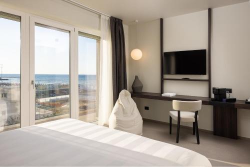 巴里B21 Lifestyle Hotel的酒店客房配有一张床和一张书桌及一台电视