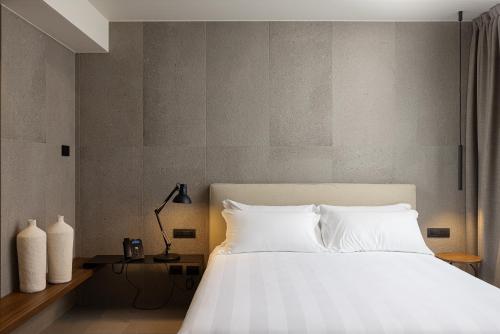 巴里B21 Lifestyle Hotel的一间卧室配有一张带白色床单的大床