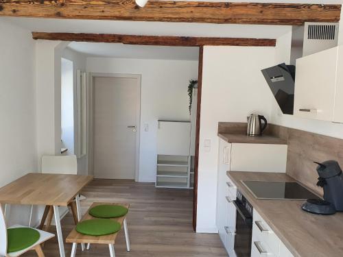 BurladingenLandgasthof Lamm Ferienwohnungen的厨房配有木桌和绿色椅子