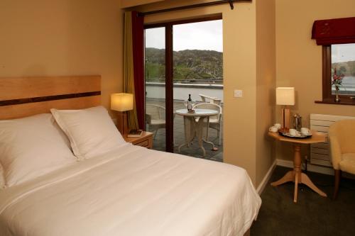 伊尼什博芬Inishbofin House Hotel的一间卧室设有一张床,享有阳台的景色