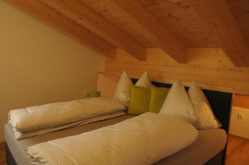 蒂罗尔-泽费尔德Haus Lagger的一张带白色床单和绿色枕头的床