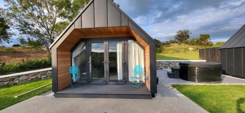 纽里The Rocks - Luxury Glamping Resort的一个带两把椅子和烤架的小棚子