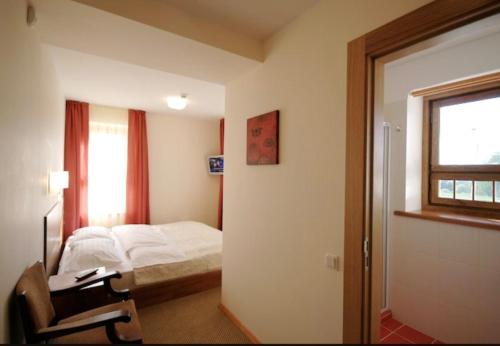 采西斯Viesnīca Atpūta的一间卧室配有一张床、一张书桌和一个窗户。