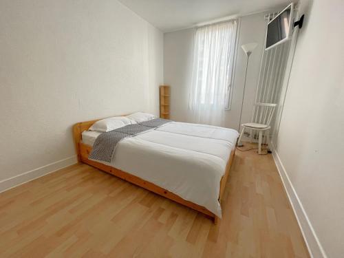 马恩河畔尚Les Aubépines entre Disney et Paris的一间卧室配有一张床,铺有木地板