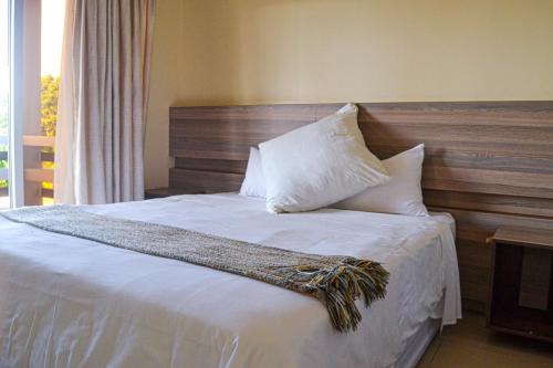 蓬塔杜欧鲁蓬塔景观酒店的一间卧室配有带白色床单和枕头的床。