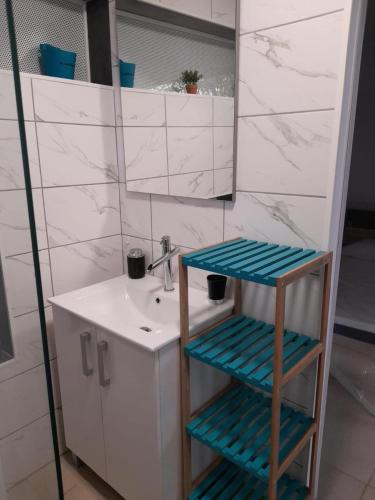 法兰西堡T2 Bambou的浴室设有水槽和镜子旁的凳子