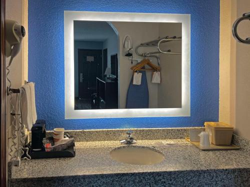 AdairsvilleQuality Inn Adairsville-Calhoun South的浴室水槽设有镜子和蓝色的墙壁
