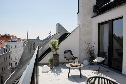 维也纳Vienna Heights Premium Apartments的大楼内的阳台配有桌椅