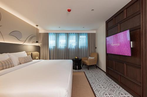 清迈Hotel Sensai Nimman Chiang Mai - Adults Only的一间酒店客房,配有一张大床和一台平面电视