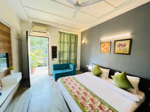 古尔冈Hotel Dayal Regency near IMT Chowk Manesar, Manesar的一间卧室配有一张大床和一张蓝色椅子