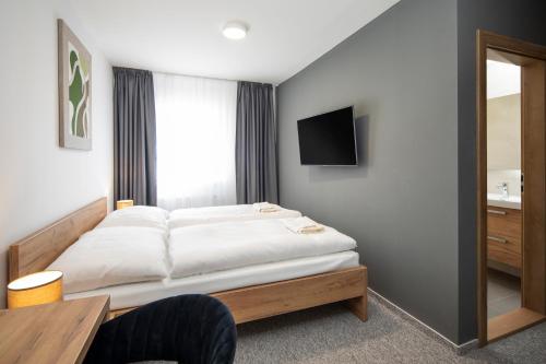 利普托夫斯奥萨达Hotel Granit Smrekovica的卧室配有一张床,墙上配有电视。