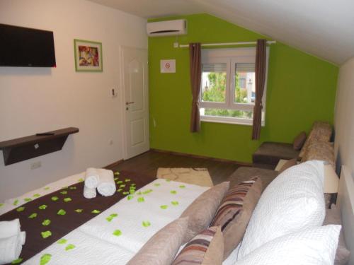 莫斯塔尔Apple Line Appartments的带沙发和绿色墙壁的客厅