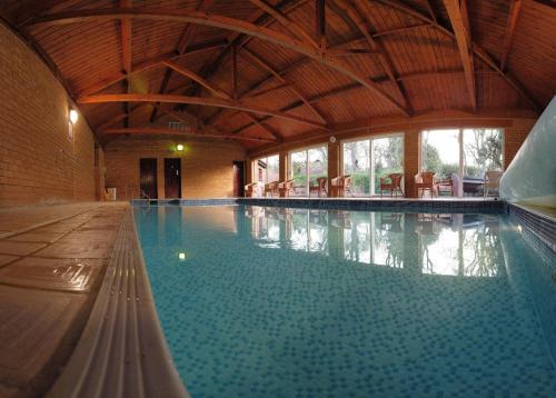 克罗默格罗夫克罗默酒店的一座带木制天花板的大型室内游泳池