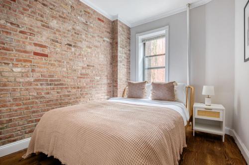 纽约East Village 2br w in-unit wd nr nightlife NYC-1236的一间卧室设有砖墙和一张床