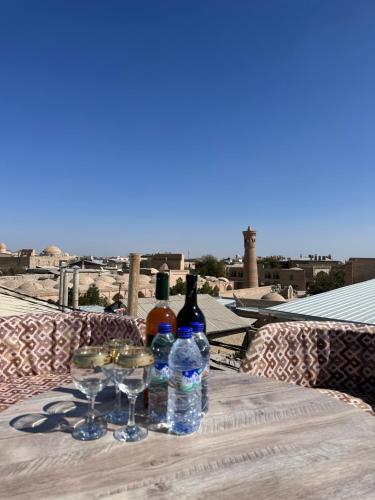 布哈拉Abuzar的阳台上配有带葡萄酒瓶和玻璃杯的桌子