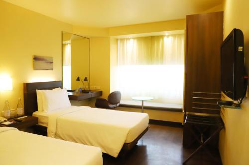 拉杰果德拉杰果德马拉萨萨罗瓦尔酒店的酒店客房设有两张床和电视。