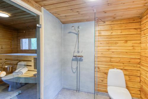 KalantiPinetree Cottages Cozy log cabin的一间带卫生间的浴室内的玻璃淋浴间