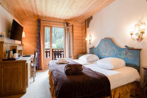 谷雪维尔La Maison Les Peupliers的一间卧室配有两张床和一张书桌。