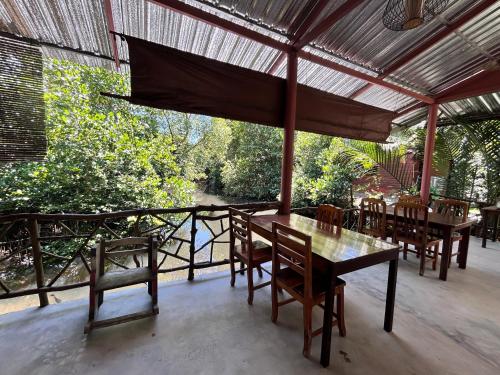 达叻府苏察纳里兰戈普度假村的门廊上的用餐室配有桌椅