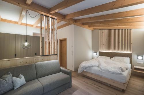 瓦尔道拉席恩克隆普拉兹博尔格度假酒店的一间卧室配有一张床和一张沙发