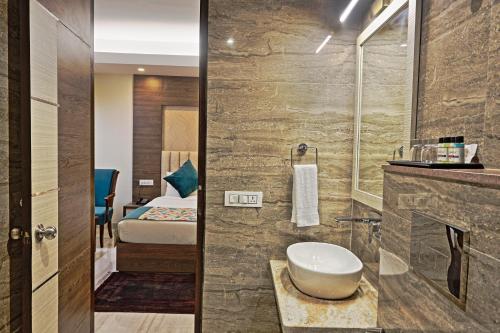 新德里Cardinal Express Oxmo的一间带水槽的浴室和一间带床的房间