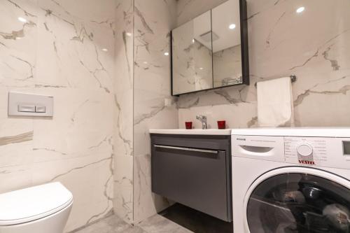 伊斯坦布尔1-bdr Apt With View Poolgym Near Airport Metro的白色的浴室内配有洗衣机。