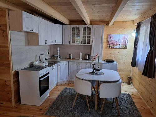 乌尔齐尼Olive & sea, Luxury two bedrooms cabin for 8的厨房配有白色橱柜和桌椅