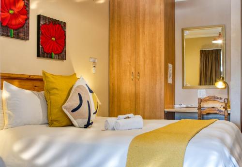 肯普顿帕克Woodpecker's Inn Guest House的卧室配有一张带黄色枕头的大型白色床。
