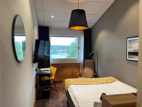 奥克什贝里亚Skåvsjöholm Hotell och Möten的客房设有床、电视和窗户。