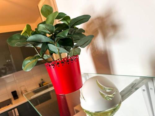 马恩河畔维列Kim -TiAM CONCIERGERIE - Standing - VILLIERS SUR MARNE - Paris Disney-Parking Gratuit的玻璃桌上一个红色花瓶和植物